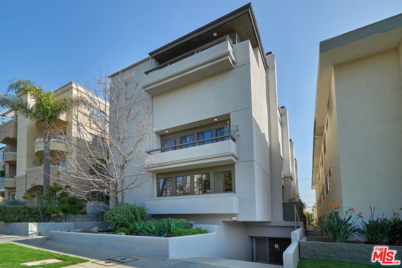 Front view of a modern multi-story building with balconies.