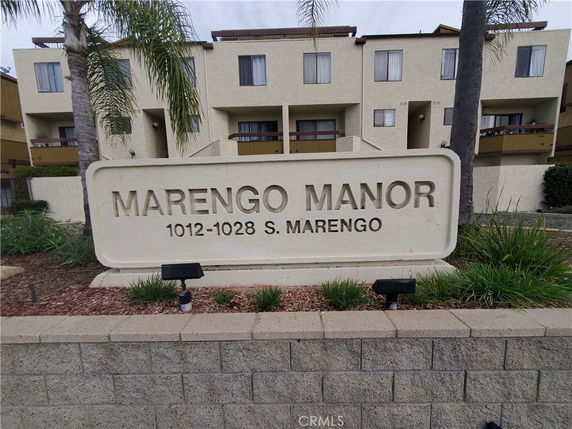 Front view of a multi-story residential building with a sign stating 'Marengo Manor 1012-1028 S. Marengo'.