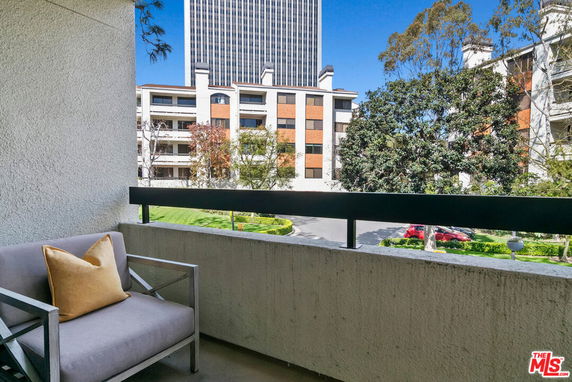 View from a balcony showing surrounding buildings and greenery.