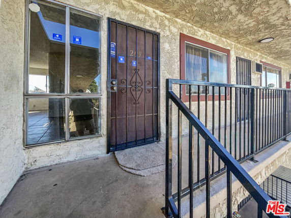 Front view of an apartment entrance with metal door and window.