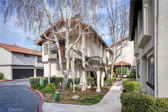 Front view of a multi-level residential building with external staircase.