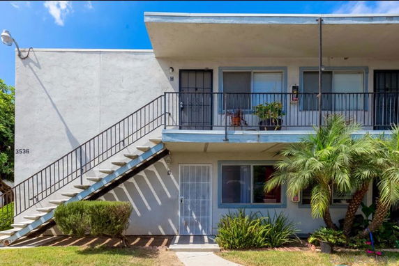 Front view of a two-story apartment building with exterior staircase.