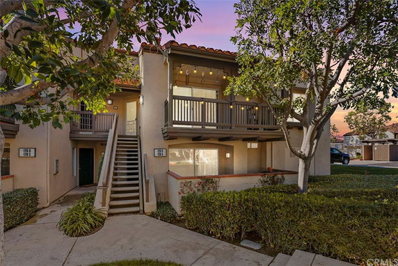 Front view of a two-story residential building with a staircase leading to the upper level.