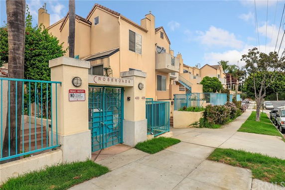 Front view of a multi-story residential building with gated entrance.