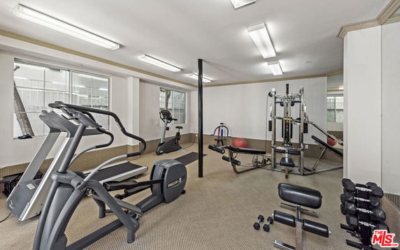 Indoor fitness gym with exercise equipment and mirrors.