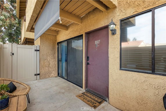 Front view of a residential building with an entry door and sliding glass door.
