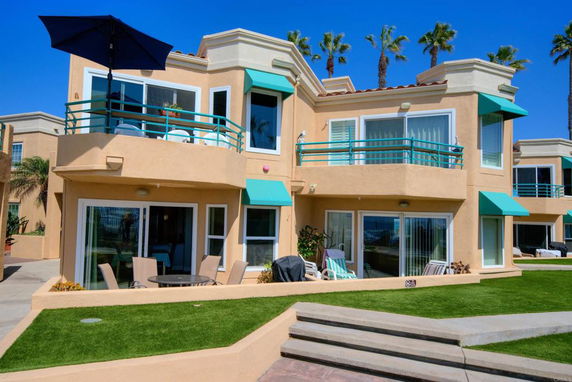 Front view of a two-story house with balconies and large windows.