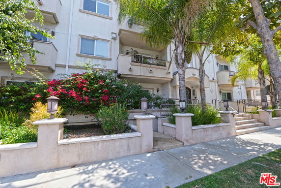 Front view of a multi-story apartment building with balconies.