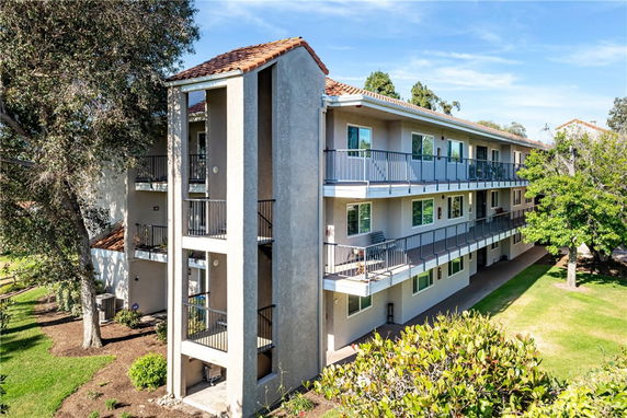 Front view of a three-story apartment building with balconies.