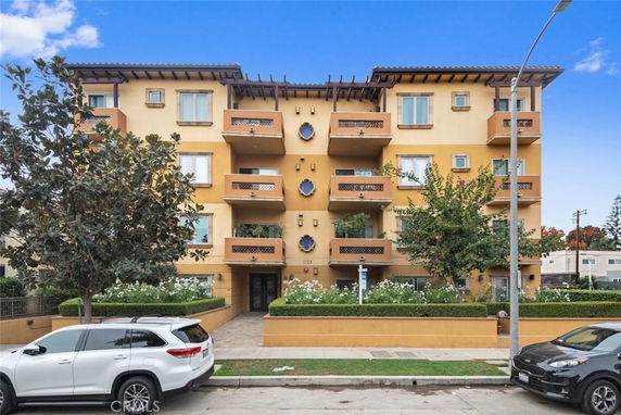 Front view of a multi-story apartment building with multiple balconies.