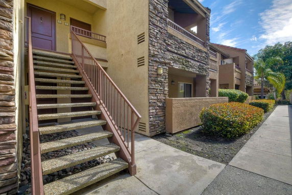 Front view of a multi-unit building with stone and stucco exterior.