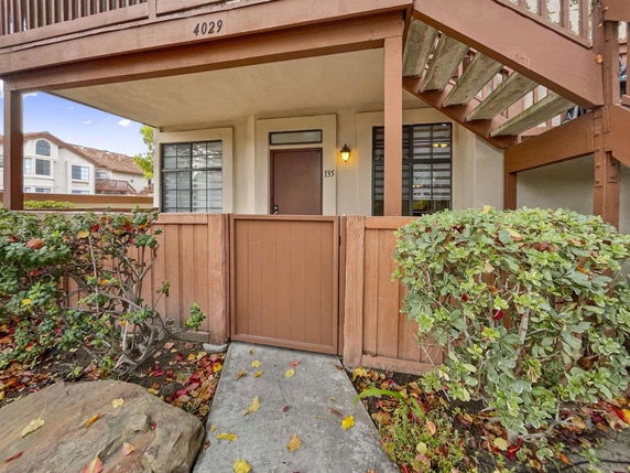 Front view of a residential building with an entrance gate and stairs.