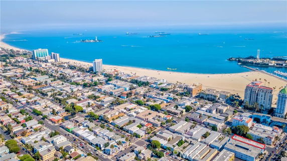 Wide-angle view of a coastal cityscape with beach and ocean.