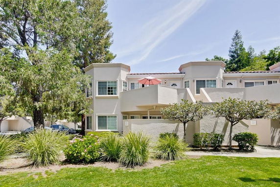 Front view of a two-story house with large windows and landscaped garden.