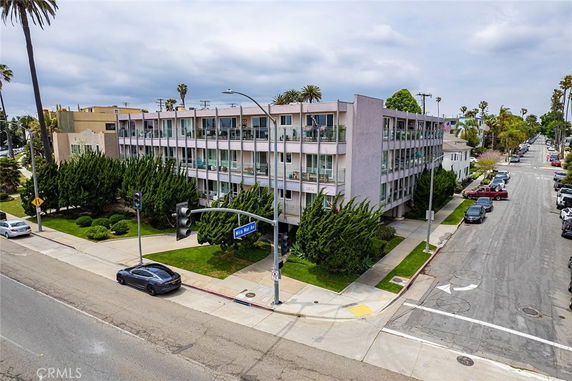 Front view of a multi-story apartment building on a street corner.