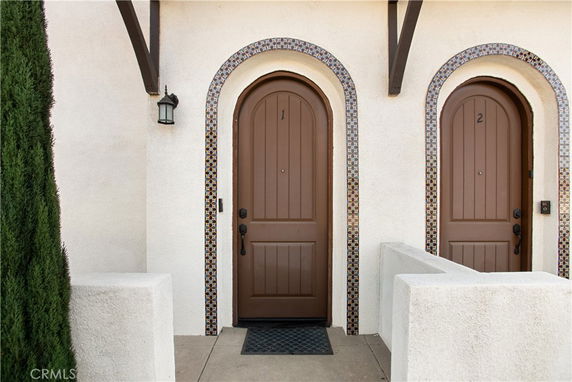 Front view of a building with arched doorways and decorative tile borders.