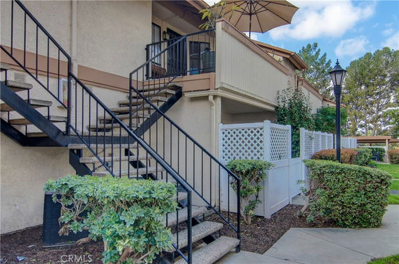 Front view of a two-story building with outdoor stairs.