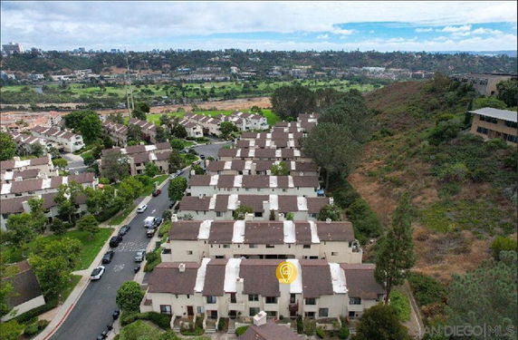 Aerial view of a residential area with multiple houses arranged in rows along a curving road.