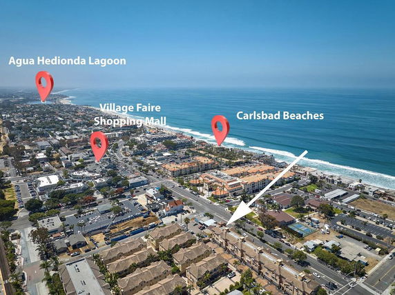 Panoramic aerial view of a coastal city with labeled landmarks including lagoon, shopping mall, and beaches.