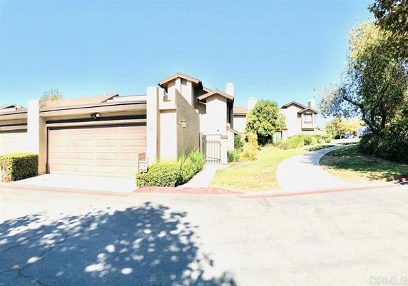 Front view of a townhouse with a garage and pathway.