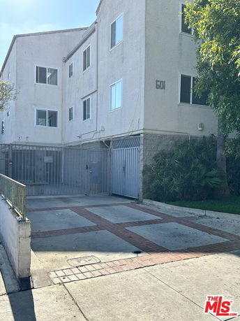 Front view of a multi-story building with gated entrance.