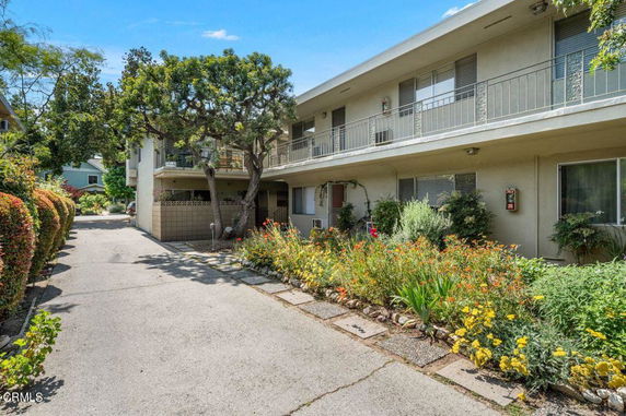 Front view of a two-story building with a pathway and garden.