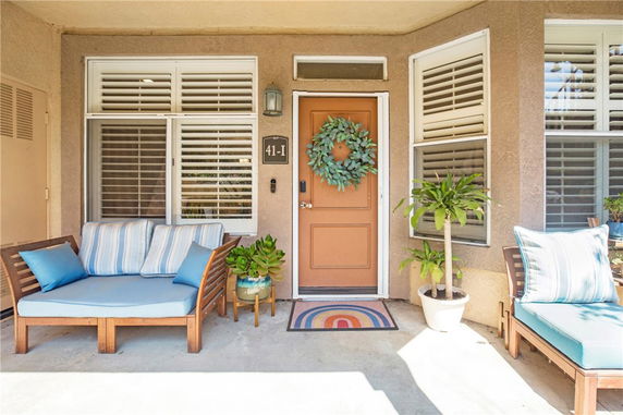 Front view of a house entrance with a seating area and decorative door wreath.