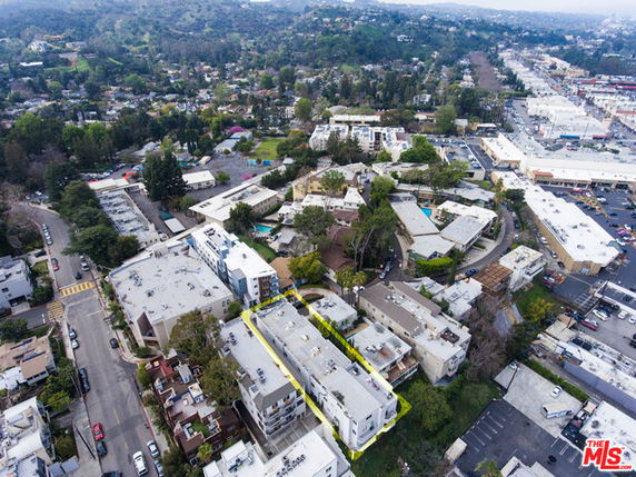 Panoramic aerial view of a residential area with multiple buildings and surrounding greenery.