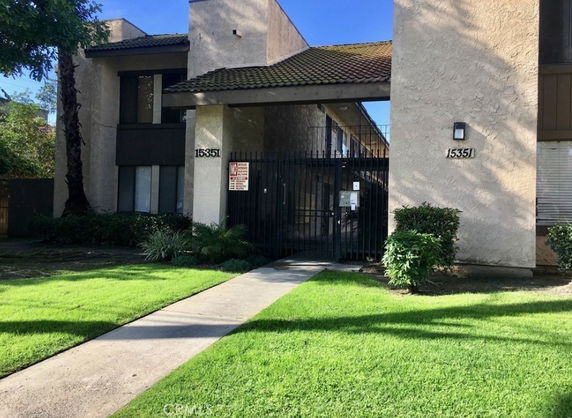 Front view of a two-story building with a gated entrance.