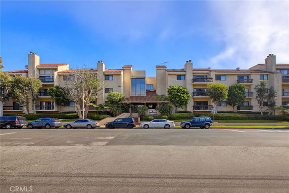 Front view of a multi-story apartment building with balconies.