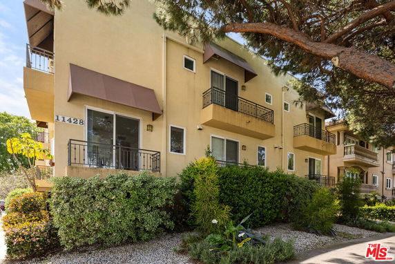 Front view of a multi-story building with balconies and awnings.