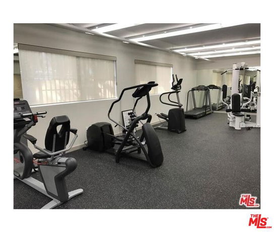 Indoor gym area with various exercise equipment including treadmills and ellipticals.