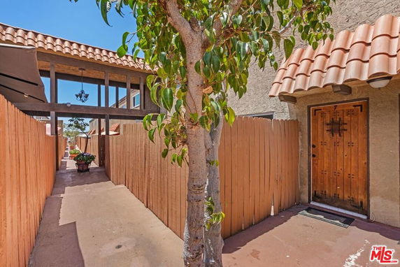 Front entrance view of a house with a wooden door and red-tiled roof.
