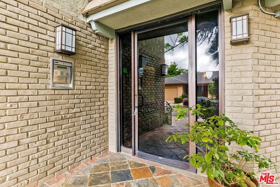 Front view of a house with brick walls and glass door entrance.