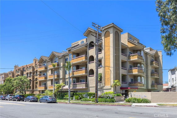 Front view of a multi-story apartment building with balconies.