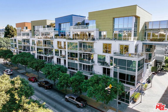Front view of a multi-story apartment building with large windows and balconies.
