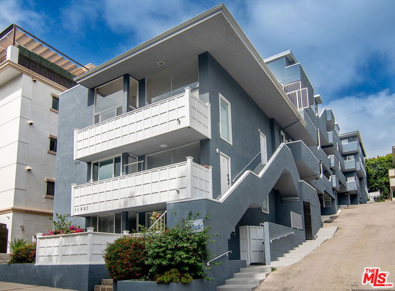 Front view of a multi-story modern apartment building with balconies.