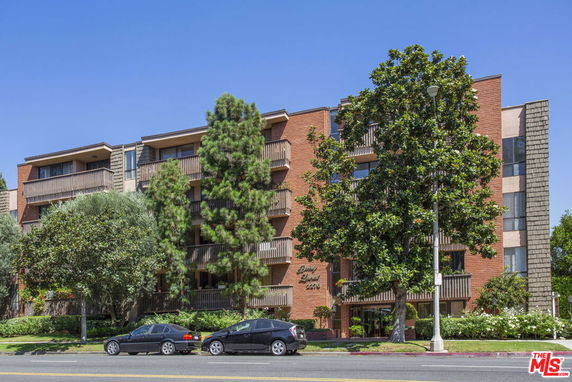 Front view of a multi-story residential building with balconies.