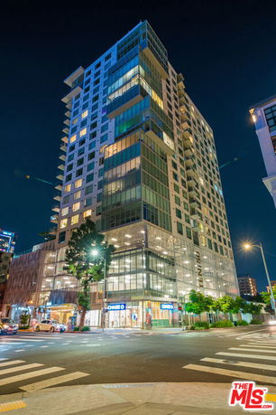 Front view of a tall, modern high-rise building at night.