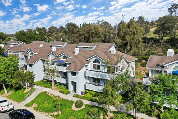 Front view of a multi-story residential building with a sloped roof and balconies.