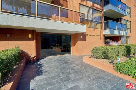 Front view of a multi-story building with glass balconies.