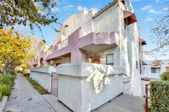 Angled view of a multi-story building with a textured facade and balconies.