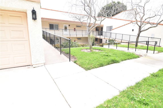 Front view of a multi-story residential building with ramp access.
