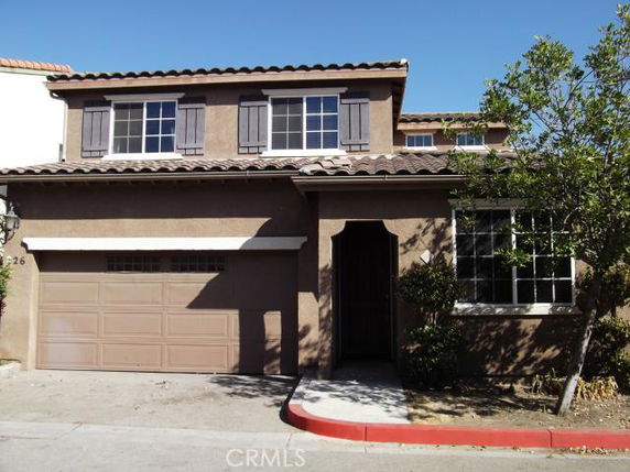 Front view of a two-story house with a double-garage and brown exterior.