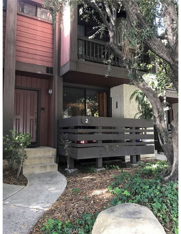 Front view of a multi-story house with a small porch and balcony.