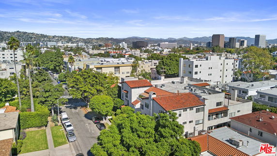 Panoramic view of a residential area with multiple buildings and distant hills.