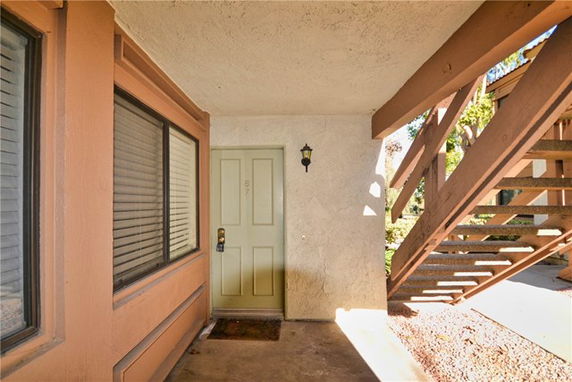 Entryway to a building with a staircase and closed door.