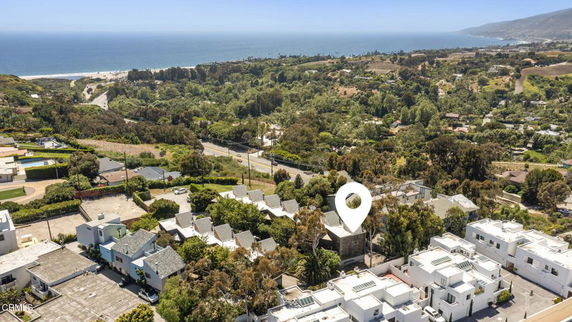 Panoramic view of a coastal area with houses and ocean in the background.