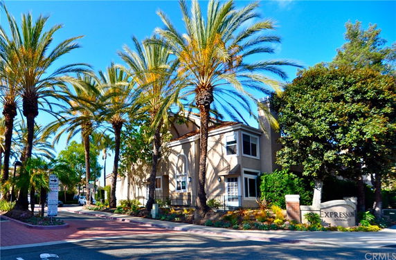 Front view of a two-story building with palm trees.