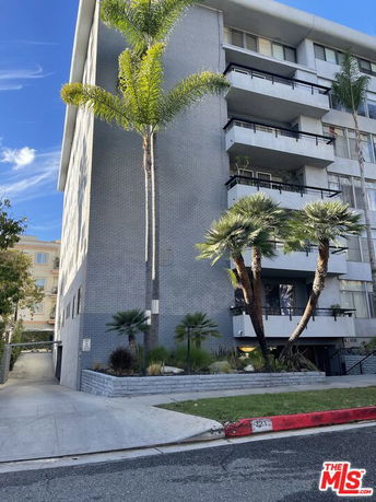 Front view of a multi-story residential building with balconies.